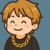 茶色系金髪の日本人男性アイドルが黒い服に太い金のネックレスを着けて笑っている様子